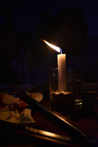 a candle sitting on a table with a plate of food at Secrets Guest House in Entebbe