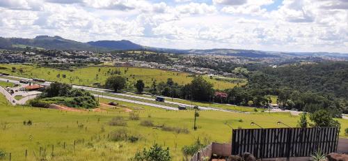 a green field with a highway in the distance at Green It Motel & Hotel in Bragança Paulista