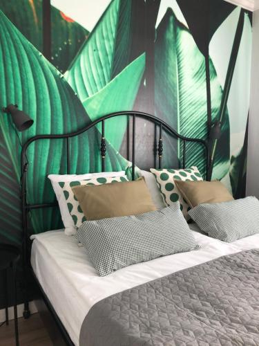 a bedroom with a bed with green and white pillows at Apartament Podmiejska 57 in Biała Podlaska