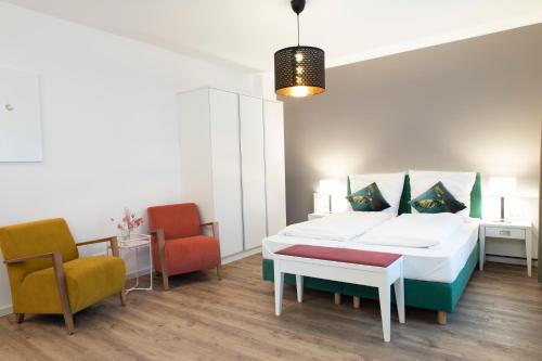 a bedroom with a bed and two chairs at Villa am Bahnhof in Fulda in Fulda