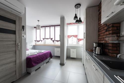 a bedroom with a bed and a kitchen with a sink at Magnetic apartment Jerozolimskie A in Warsaw