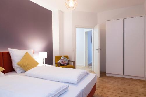 a bedroom with a white bed and a chair at Villa am Bahnhof in Fulda in Fulda
