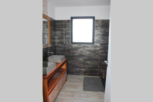 une salle de bain avec un lavabo et une fenêtre dans l'établissement Maison contemporaine, à Saint-Privat-de-Champclos