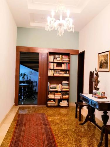 a living room with a table and a chandelier at Casa Fazenda Inglesa Petrópolis RJ in Petrópolis