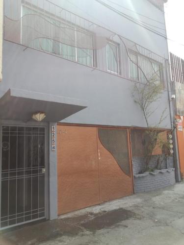 a building with a wooden door with a ramp on it at Coyotito Beds Coyoacan Confort y flexibilidad in Mexico City