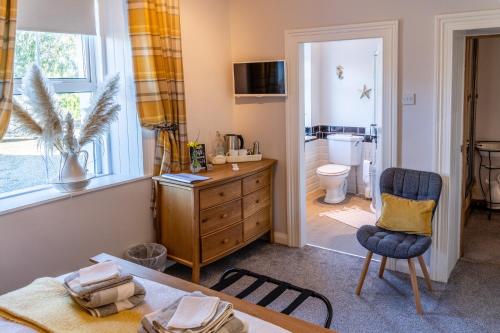 a room with a table and a chair and a bathroom at The Mulberrys B&B in Downpatrick