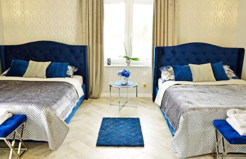 niebieska sypialnia z 2 łóżkami i stołem w obiekcie Sieburczynianka w mieście Wizna
