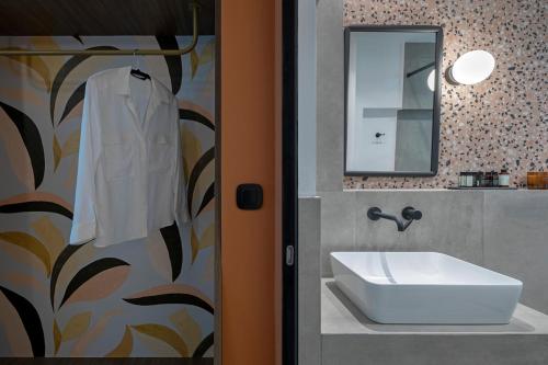 a bathroom with a sink and a mirror at Acro Urban Suites in Athens