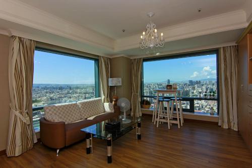 Luxury House في تايتشونغ: غرفة معيشة مع أريكة ونوافذ كبيرة
