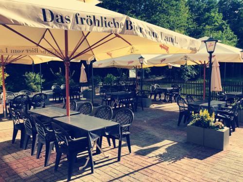 an outdoor restaurant with tables and chairs and umbrellas at Gasthof Wilhelm Tell Fremdenzimmer in Zirndorf