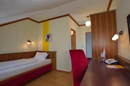 a bedroom with a bed and a desk with a phone at Hotel Deutsches Haus in Hammelburg
