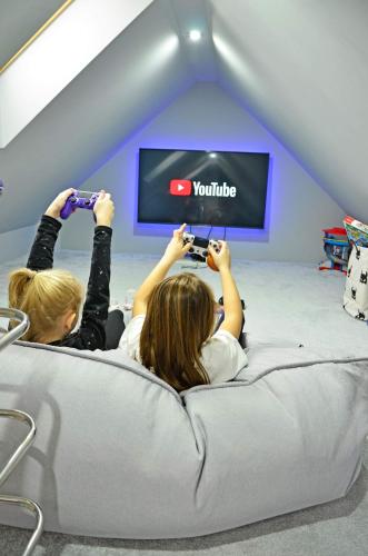 two girls laying on a bed playing video games at Sieburczynianka in Wizna