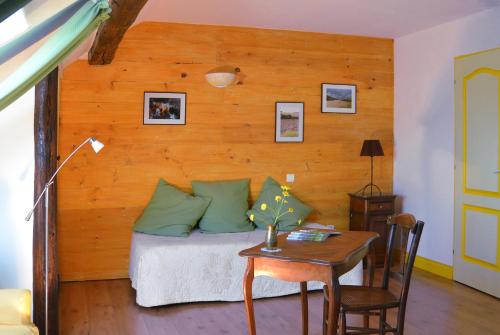 - une chambre avec un lit doté d'oreillers verts et d'une table dans l'établissement Le Clos des Pommes, à Bioncourt