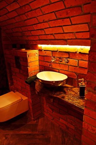 a bathroom with a sink and a brick wall at Sieburczynianka in Wizna