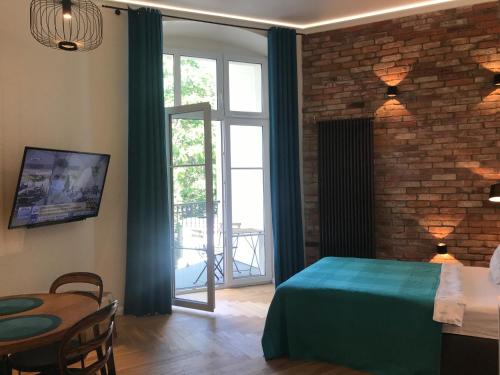 a bedroom with a green bed and a brick wall at My Place in Poznan Centrum in Poznań