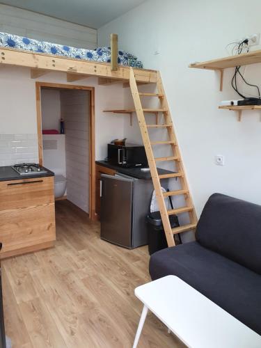 uma sala de estar com uma cama alta e uma cozinha em Angers Green Lodge - Cosy Studio em Angers