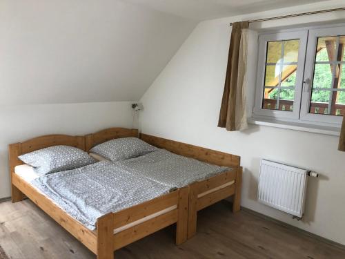 um quarto com uma cama e uma janela em Chalupa U sjezdovky, Zadov 22 em Stachy