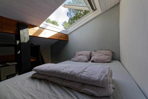 - une petite chambre avec un lit et une fenêtre dans l'établissement Villa sous les pins de Moliets, à Moliets-et-Maa