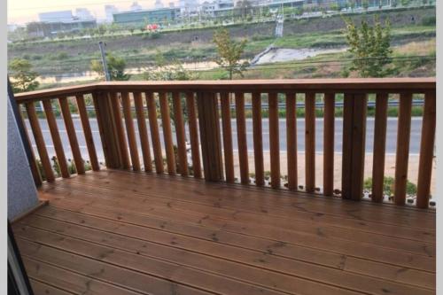 a wooden balcony with a view of the beach at Grace River House Block A in Hoengseong