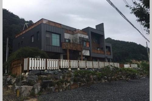 a house on top of a hill with a fence at Grace River House Block A in Hoengseong
