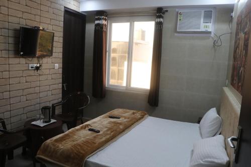 a bedroom with a bed and a window at Krishna Dreams in Haridwār