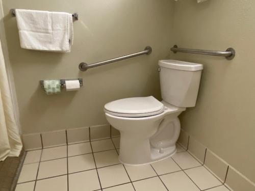 a bathroom with a toilet and towels on the wall at Clarion Inn Harpers Ferry-Charles Town in Harpers Ferry