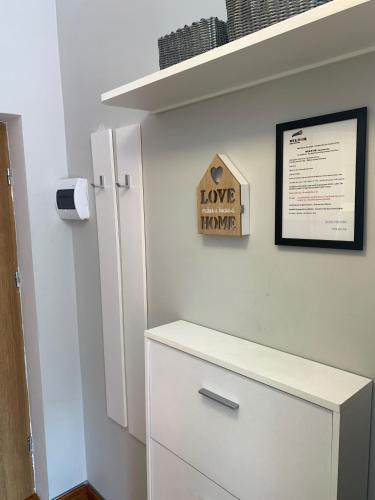 a room with a white cabinet and a sign that reads love ignore at VULTOR Apartments in Wrocław