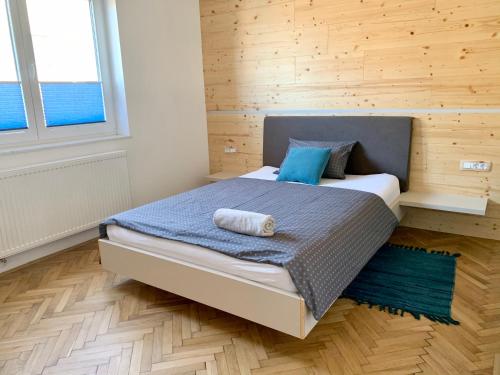 a bedroom with a bed with blue pillows on it at Kamr’ca in Ljubljana