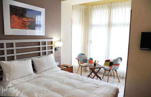 a bedroom with a bed and a table and chairs at Pension Subirats Perello in Perelló