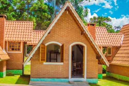 a small brick house with a pitched roof at Pousada Vale Verde in Monte Verde