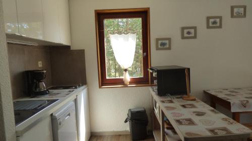 a kitchen with a window and a table with a television at QUEYRAS in Ceillac