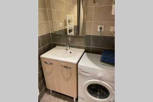 een badkamer met een wasmachine en een wastafel bij La bâtisse de Chabot N°5 ( 4 couchages) in Montluçon