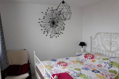 - une chambre avec un lit bébé blanc et un couvre-lit floral dans l'établissement 2 pièces - Cabine et terrasse Véranda - GRAU DU ROI -, au Grau-du-Roi