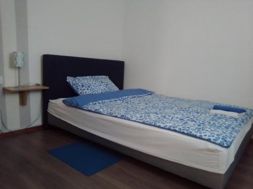 een slaapkamer met een bed met een blauw dekbed bij Sobe Ana in Sombor