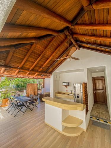 an open kitchen and living room with wooden ceilings at Villas Sunrisa in Zihuatanejo