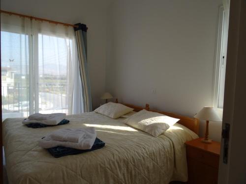 - une chambre avec un lit et 2 serviettes dans l'établissement Andromeda Beach house, à Pólis Chrysochoús