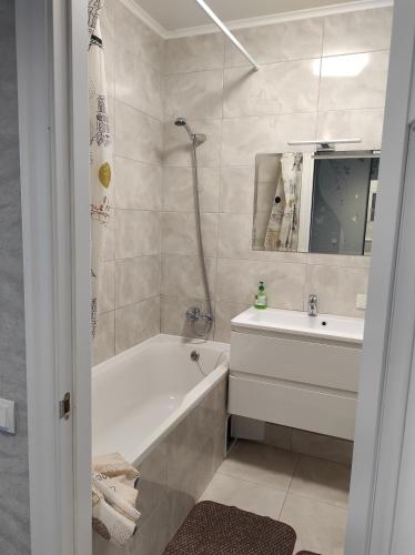 ein Badezimmer mit einer Badewanne und einem Waschbecken in der Unterkunft Апартаменти Люкс2 in Chmelnyzkyj