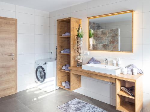 a bathroom with a sink and a washing machine at Traumferienhaus XXL Ortner in Wetzendorf