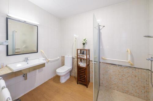 a bathroom with a toilet and a sink and a shower at Hotel Torres Manlleu in Manlleu