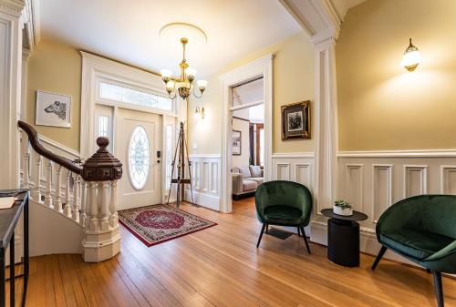 a living room with a staircase and green chairs at The Copeland in Revelstoke