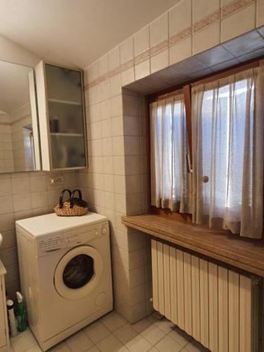 a laundry room with a washing machine and a window at La Sibilla in Macerata
