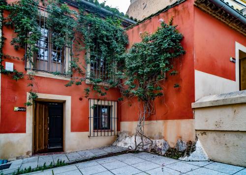 a red building with plants growing on it at Hotel Alfonso IX in Cáceres