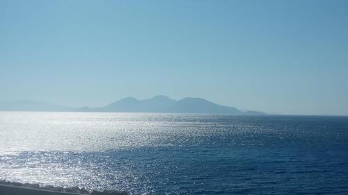 a view of the ocean with mountains in the distance at Mythical Ikaria, Therma tiny two floors apartment in Agios Kirykos