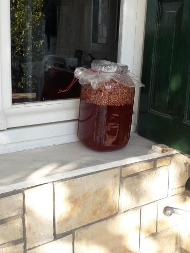 a jar of honey sitting on a window sill at Mythical Ikaria, Therma tiny two floors apartment in Agios Kirykos