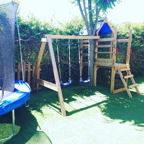 a playground with a swing and a tree at El Mirador De Ruidera in Ruidera