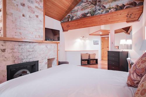 a bedroom with a bed and a fireplace at Rainbow by Outpost Whistler in Whistler