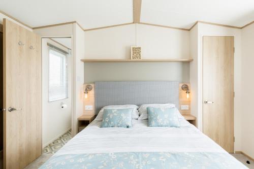 een slaapkamer met een groot bed met blauwe kussens bij Lilly Pad in South Cerney