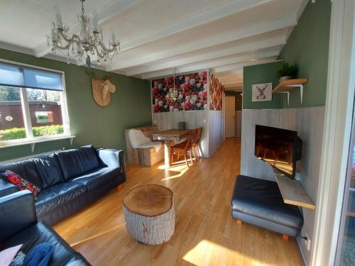 a living room with a couch and a fireplace at Chalet Hoenderloo Den in Hoenderloo