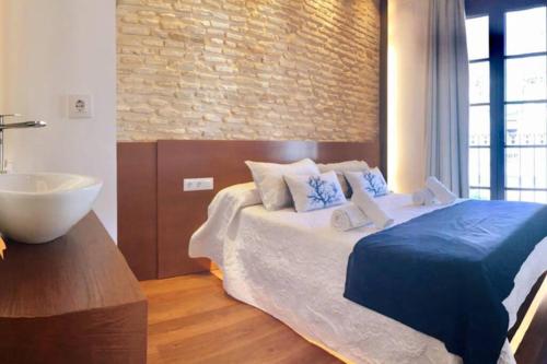 a bedroom with a large bed and a sink at Casa de diseño 200m Mezquita 2 rooms & 2 bathrooms in Córdoba