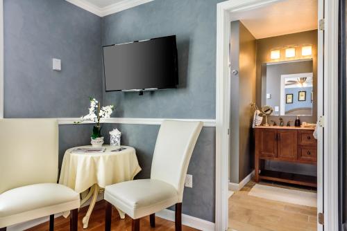 een eetkamer met een tafel en stoelen en een televisie bij Bouchard Restaurant & Inn in Newport